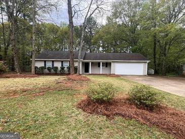 Charming single-story home featuring a well-maintained lawn and a two-car garage at 260 Countryside Ln, Covington, GA 30016