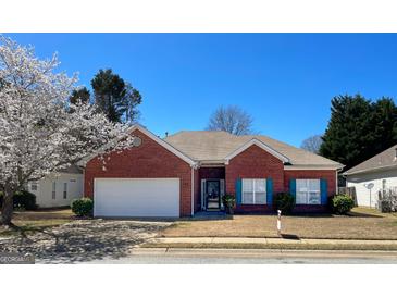 Charming one-story red brick home with well-manicured lawn, flowering trees, and a two-car garage at 325 Autumn Glen Cir, Fayetteville, GA 30215