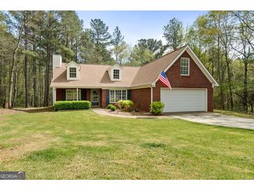 Charming one-story brick home features a manicured lawn and attached two-car garage at 1022 Miss Amber Way, Locust Grove, GA 30248