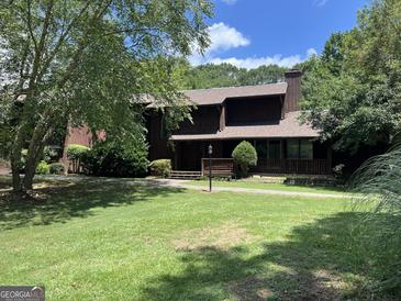 Charming two-story home featuring a well-maintained lawn and mature trees on a sunny day at 20 Fairway Ln, Peachtree City, GA 30269