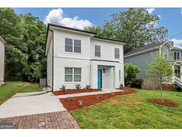 Charming two-story home featuring a modern design with a bright blue front door and fresh landscaping at 1188 Oakland Sw Ln, Atlanta, GA 30310