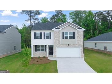 Charming two-story home featuring white brick, black shutters, and a well-manicured lawn at 600 Whitman Ln # 2026, Stockbridge, GA 30281