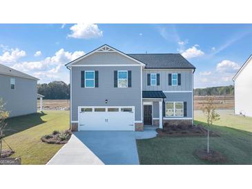 Charming two-story home featuring a two-car garage, gray siding and black shutters on a sunny day at 596 Whitman Lane # 2025, Stockbridge, GA 30281