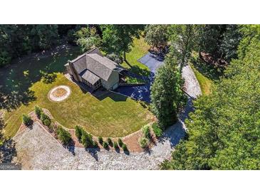 Aerial view of a home with a circular driveway, surrounded by lush greenery and mature trees at 250 Hester Rd, Carrollton, GA 30116