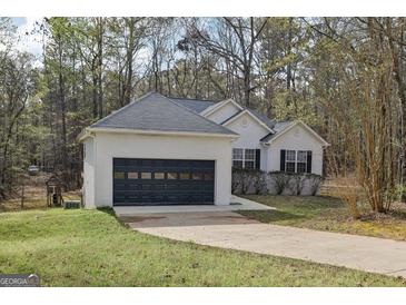 Charming single story home boasts an attached garage and well-maintained landscaping at 75 Bretts Bnd, Sharpsburg, GA 30277