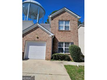 Charming brick two-story home featuring an attached garage and well-maintained landscaping at 530 Shadowmoore Dr, Riverdale, GA 30274