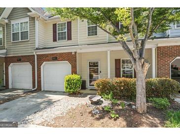 Charming townhome with attached garage and inviting front entrance with landscaped garden at 949 Pike Forest Dr, Lawrenceville, GA 30045