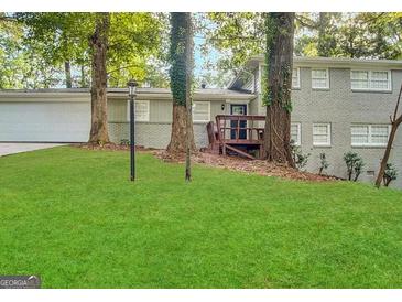 Charming brick home featuring a lush green lawn and a cozy front porch at 518 Hammett Dr, Decatur, GA 30032