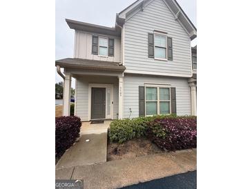 Inviting townhouse featuring classic siding, complemented by charming landscaping at 7703 Fawn Cir, Covington, GA 30014