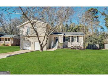 Charming two-story home with a well-maintained lawn, attached garage, and inviting front entrance at 2317 Emerald Springs Dr, Decatur, GA 30035