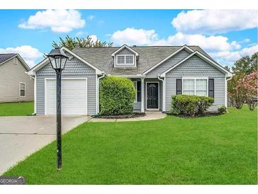 Charming single story home with a well-maintained lawn and attached one car garage at 315 Breezy Hill Walk, Stockbridge, GA 30281