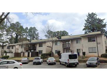 Apartment building featuring traditional architecture, outdoor parking, and mature trees at 3834 Kensingwood Trce, Decatur, GA 30032