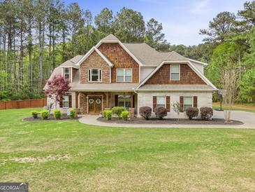 Charming two-story home featuring stone and shingle accents, manicured landscaping, and an inviting walkway at 100 Chantilly Ln, Fayetteville, GA 30215