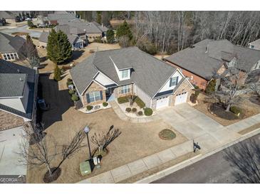 Expansive aerial view of brick and siding home with mature landscaping and a three-car garage at 409 Brandy Ln, Mcdonough, GA 30253
