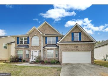Charming two-story home with brick facade, blue shutters, and well-manicured landscaping at 540 Hamlet Dr, Hampton, GA 30228