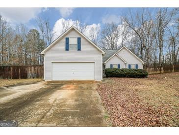 Charming single-Gathering home with a two-car garage and a cozy, landscaped front yard at 1103 Larkspur Dr, Locust Grove, GA 30248
