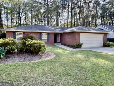 Charming brick home with a well-manicured lawn, inviting curb appeal, and attached two-car garage at 116 Glendale Dr, Peachtree City, GA 30269