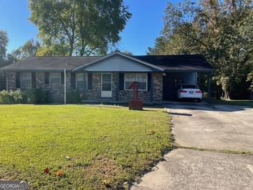 Charming one-story brick home with a covered carport and a well-maintained front yard at 266 Ridge Trl, Riverdale, GA 30274
