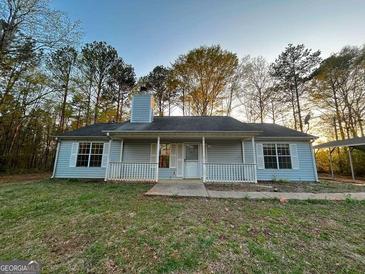 Charming single-story home with a covered front porch and large front yard surrounded by mature trees at 117 Old Stagecoach Rd, Carrollton, GA 30116