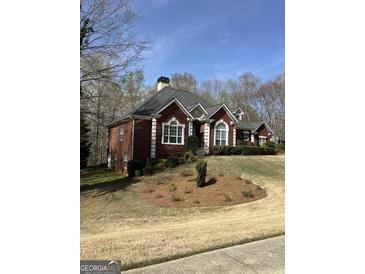 Charming brick home featuring manicured landscaping and a classic architectural design with a well-maintained lawn at 9039 River Bend Ct, Villa Rica, GA 30180