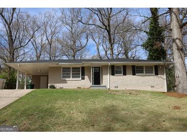 Charming brick home featuring a well-maintained lawn and a convenient carport at 1751 Woodsloe Dr, Decatur, GA 30035