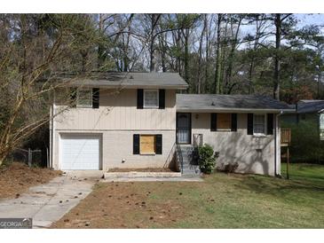 Two-story house with a garage, front lawn, and some trees around the house at 4044 Lindsey Dr, Decatur, GA 30035