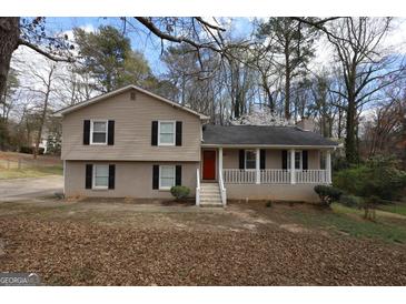 Charming split-level home with a cozy front porch, brick accents, and a red front door at 756 Sugar Hill Ln, Conyers, GA 30094