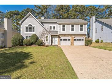 Charming two-story home with stone accents, attached two-car garage, and well-maintained lawn at 4180 Pineset Dr, Alpharetta, GA 30022