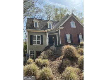 Charming two-story home with a combination of brick and siding, complemented by black shutters and a well-maintained front yard at 1081 Bridge Mill Ave, Canton, GA 30114
