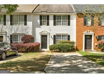 Inviting townhome featuring well-maintained landscaping and a private driveway at 5599 Fair Creek Way, Lithonia, GA 30038