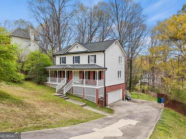 Charming two-story home with a brick foundation, inviting front porch, and well-maintained landscaping at 4435 Ross Estates Ct, Snellville, GA 30039