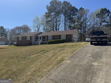 Charming brick home with manicured lawn and driveway, perfect for suburban living at 222 Farmbrook Pkwy, Stockbridge, GA 30281