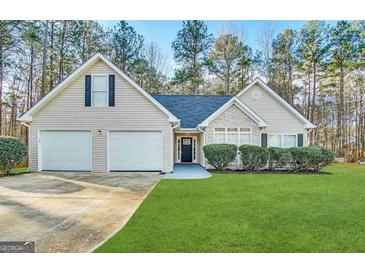 Charming single Gathering home featuring manicured lawn, two car garage, and stone facade at 596 Carlton Rd, Palmetto, GA 30268