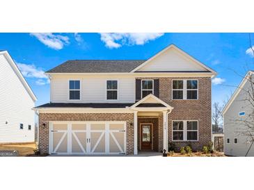 Inviting two-story brick home featuring an attached garage and a covered entryway at 1619 Tide Mill Rd, Cumming, GA 30040