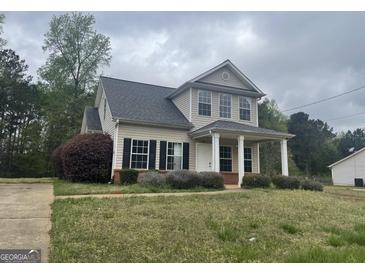 Charming two-story home featuring a covered front porch and well-maintained landscaping at 50 Autumn Ct, Covington, GA 30016