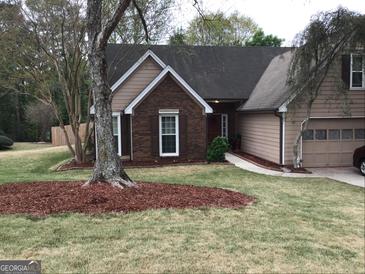 Charming two-story home featuring brick accents, an attached garage, and a well-maintained lawn at 3221 Rock Creek Dr, Rex, GA 30273
