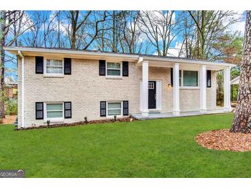 Charming brick home featuring black shutters, white columns, and a well-maintained front lawn at 2786 Altaview Se Dr, Atlanta, GA 30354
