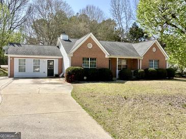 Charming one-story brick home with well-maintained lawn, driveway, and mature trees in a quiet neighborhood at 4 Bonnie Glen Ln, Hampton, GA 30228