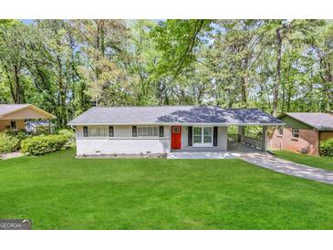 Charming single-story home with red front door, lush lawn, and attached carport at 837 Needle Rock Dr, Stone Mountain, GA 30083