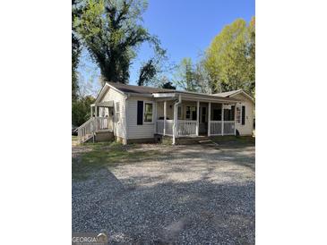 Charming single story home with a front porch and gravel yard at 104 14Th St, Cumming, GA 30040