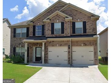 Charming two-story brick home featuring a two-car garage, well-maintained lawn, and classic black shutters at 3620 Pickeral St, Fairburn, GA 30213