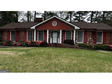 Charming red brick home with a well-manicured lawn and landscaped flowerbeds at 2760 The Fontainebleau Sw, Atlanta, GA 30331
