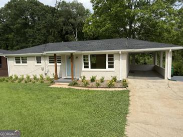 Charming home featuring a covered carport, fresh landscaping, and a welcoming blue front door at 2502 Miriam Ln, Decatur, GA 30032