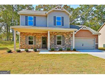 Charming two-story home featuring stone accents, a covered porch, and an attached two-car garage at 648 Stevens Pl, Mcdonough, GA 30252
