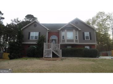 Charming two-story home featuring wood and brick, a landscaped yard, and a welcoming front entrance at 1742 Pine Fort Cir, Dacula, GA 30019