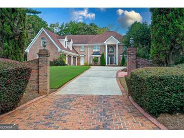Impressive brick home featuring a well-manicured lawn and a long driveway with brick accents at 157 Glen Eagle Way, Mcdonough, GA 30253