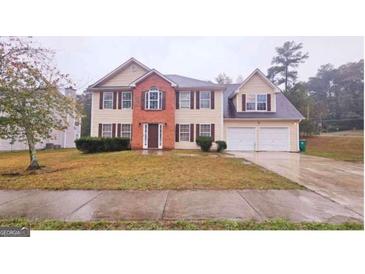 Charming two-story home featuring a symmetrical facade, brick accents, and a well-maintained front lawn at 1857 Oak Hill Springs Blvd, Lithonia, GA 30058