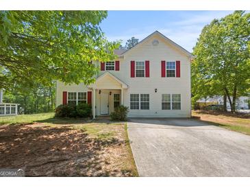 Inviting two-story home with red shutters, a well-manicured lawn, and mature trees at 60 Charlotte Blvd, Stockbridge, GA 30281