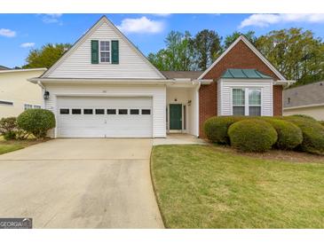 Charming home featuring a one-car garage, lovely lawn and manicured shrubs at 161 Spring Creek Blvd, Mcdonough, GA 30253