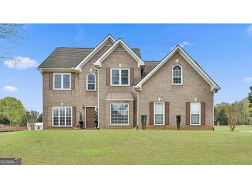 Two-story brick home featuring manicured lawn and multiple double hung windows at 198 Crestwood Rd, Tyrone, GA 30290